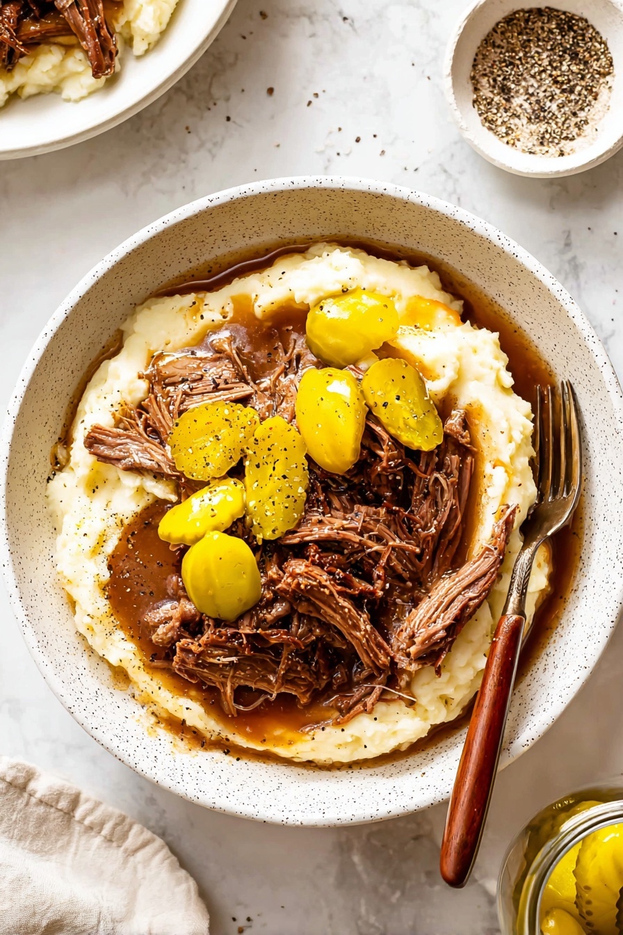 A white speckled bowl holds a layered dish starting with a thick base of creamy mashed potatoes in off-white color with a smooth texture, topped with shredded brown meat covered in rich brown gravy. Around and on top of the meat, there are several whole bright yellow pickled peppers with a glossy texture. Black pepper bits are sprinkled over the meat and mashed potatoes. A fork with a wooden handle rests inside the bowl on the right side. The bowl sits on a white marbled surface with a small white dish containing crushed black pepper and a jar with more yellow pickled peppers visible nearby. photo taken with an iphone --ar 2:3 --v 7