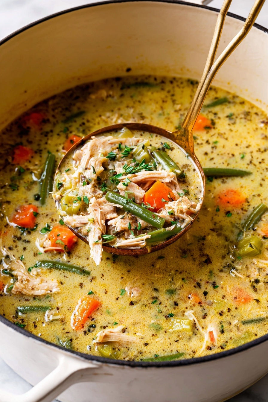 A white pot filled with creamy soup showing a rich mix of ingredients in one layer: orange carrot chunks, green beans, light brown shredded chicken pieces, and small pieces of celery, all immersed in a thick, yellowish broth with black specks of herbs. A golden ladle scoops up part of the soup, highlighting the same colorful contents, with bits of fresh green herbs sprinkled on top. The pot is set on a white marbled surface. photo taken with an iphone --ar 2:3 --v 7