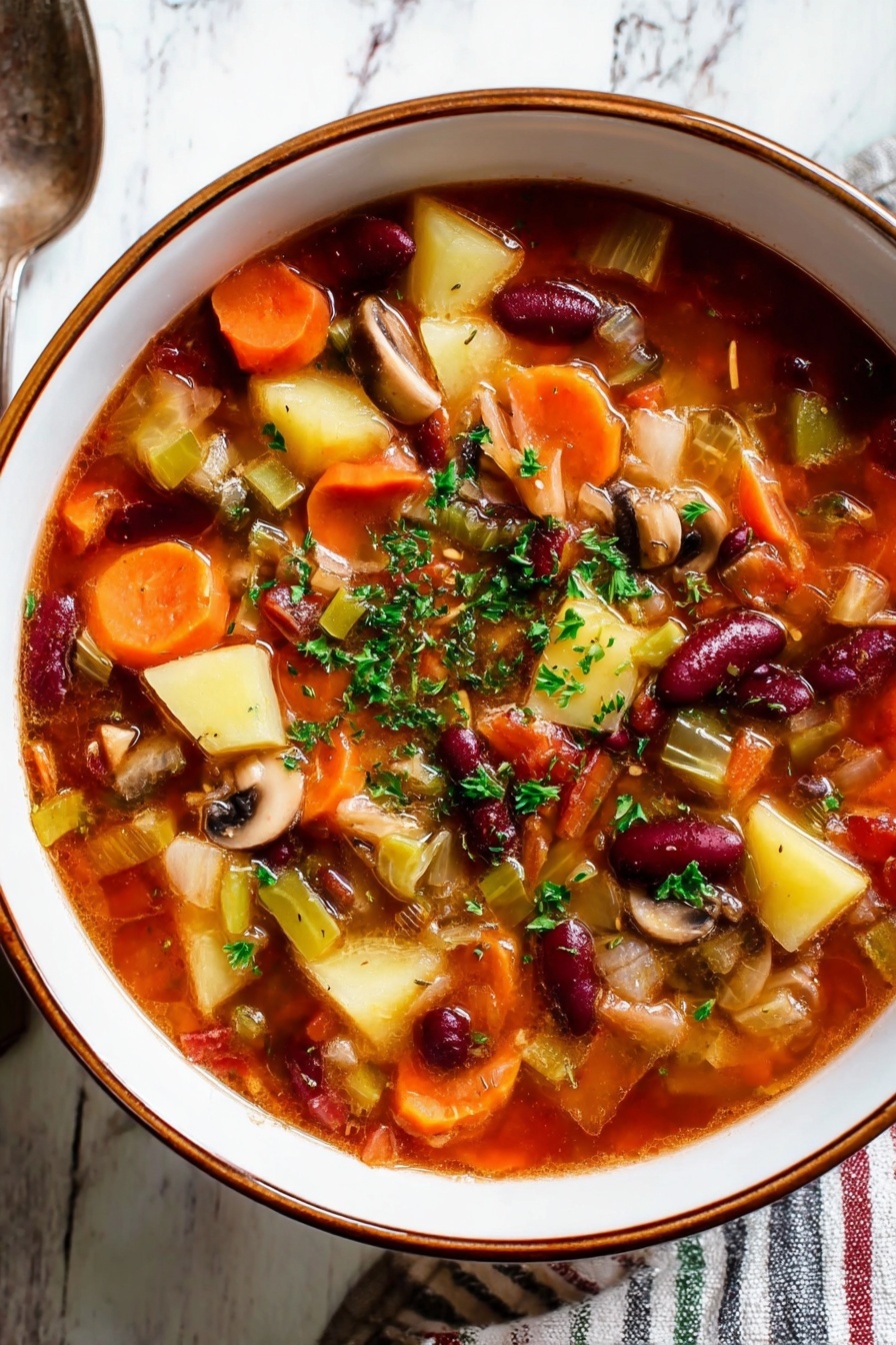 A close-up view of a white bowl filled with chunky vegetable soup, held by a woman's hand on the right edge. The soup has many layers of vegetables visible: bright orange carrot slices, dark red kidney beans, green beans, and pale pieces of cabbage, all in a rich, reddish-brown broth. Fresh green herbs are sprinkled generously on top and throughout the soup. The bowl is on a white marbled surface with hints of other dishes blurred in the background, creating a cozy and fresh look. photo taken with an iphone --ar 2:3 --v 7