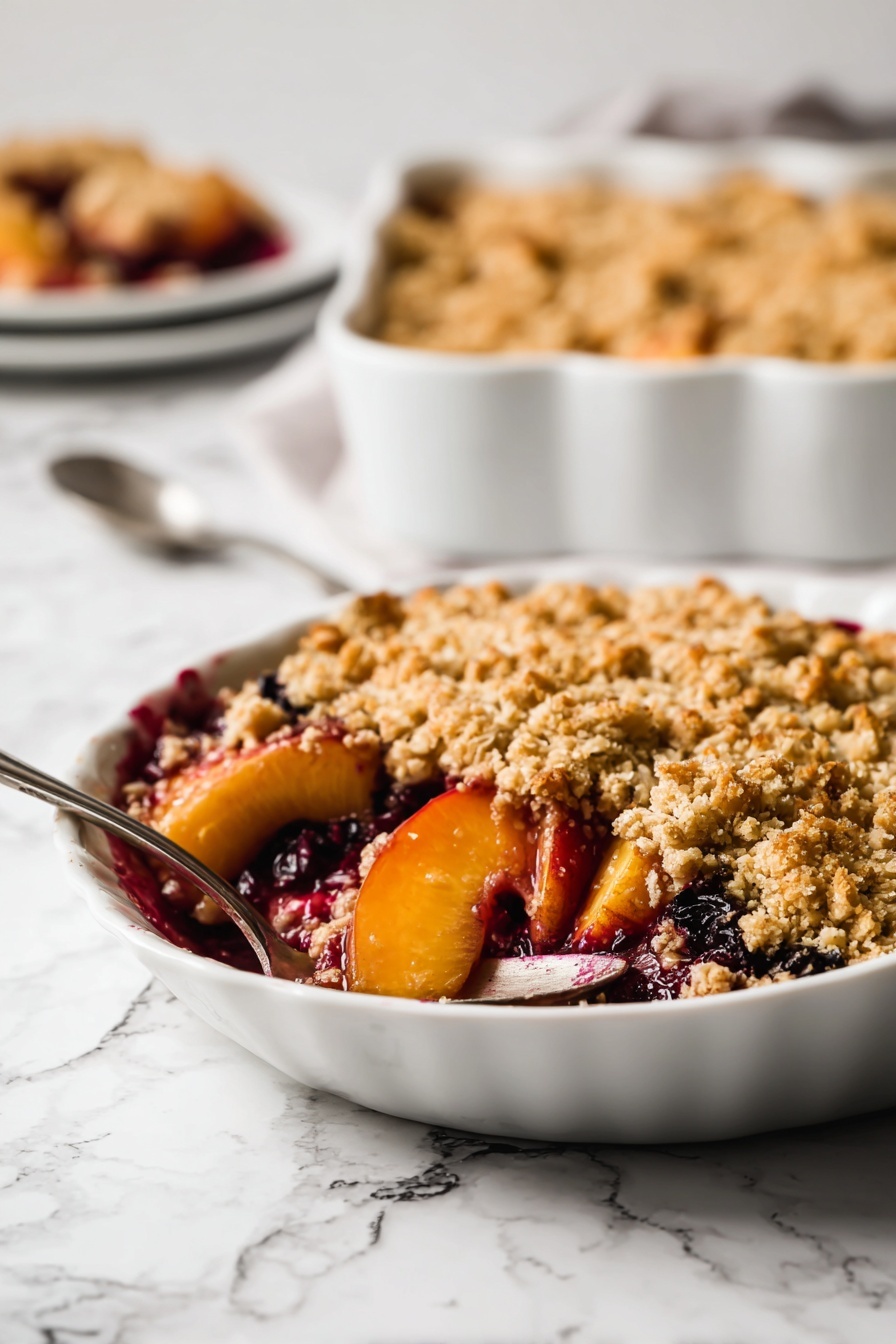 A close-up of a white oval baking dish filled with a fruit crumble. The bottom layer shows juicy, dark red berries mixed with yellow chunks of fruit, with juices bubbling up around the edges. The top layer is a thick, uneven crumb crust that is golden brown and crumbly, covering most of the fruit but leaving some juices visible around the sides. The dish is set on a white marbled surface, with some spilled reddish juice on the dish's edge. photo taken with an iphone --ar 2:3 --v 7