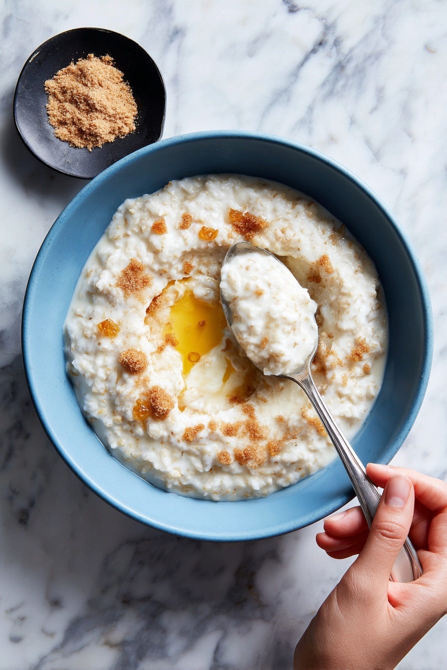 The image shows a close-up of a pot filled with oatmeal being stirred by a wooden spoon. The oatmeal is light beige with visible grains and a soft, creamy texture, slightly bubbling on the surface. The pot is silver metal and sits on a black stove grate, with part of the handle visible on the left side. The wooden spoon is partially submerged in the oatmeal, angled from the left bottom corner toward the center. photo taken with an iphone --ar 2:3 --v 7